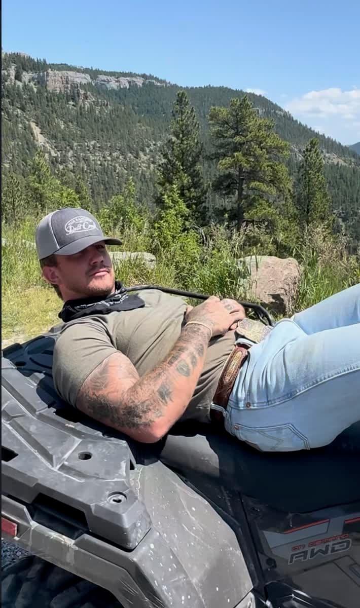 Trevor relaxing on ATV in the mountains